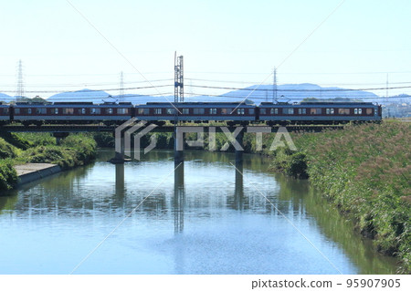 A Kintetsu train passing over an iron bridge A Kintetsu train passing over an iron bridge 95907905