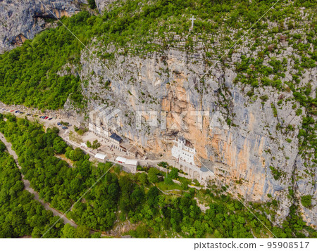 Monastery of Ostrog, Serbian Orthodox Church situated against a vertical background, high up in the large rock of Ostroska Greda, Montenegro. Dedicated to Saint Basil of Ostrog 95908517