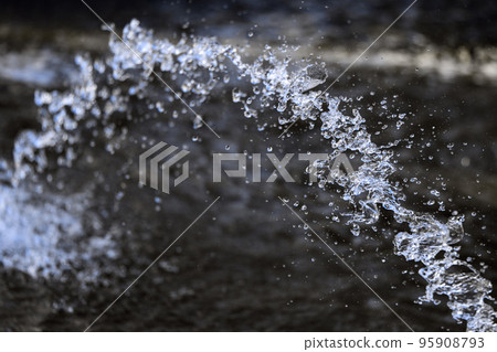 Water splashing from the fountain, jet, aqua drops, clear liquid splash on dark background 95908793