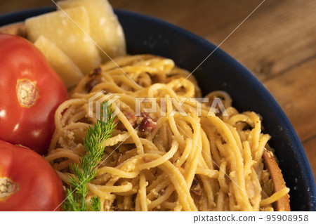 Pasta alla carbonara with bacon and parmesan with cream sauce in frying pan on rustic brown background. Pasta alla carbonara with bacon and parmesan with cream sauce in frying pan on rustic brown background. 95908958