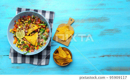 Salad texas caviar. Vegetable dish with corn, beans, pepper, pepper, tomatoes, beans. Served with corn chips nachos. Copy space Salad texas caviar. Vegetable dish with corn, beans, pepper, pepper, tomatoes, beans. Served with corn chips nachos. Copy space 95909117