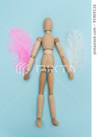 Wooden figure of a man with wings feather. Feathers abstract. Freedom concept. Vertical photo Wooden figure of a man with wings feather. Feathers abstract. Freedom concept. Vertical photo 95909138