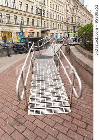 Steel Ramp for wheelchairs at subway entrance on street. Metal ramp for people. Steel Ramp for wheelchairs at subway entrance on street. Metal ramp for people. 95909252