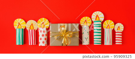 Paper cut Christmas candles and presents, gifts on red table. Winter holiday background. Christmas greeting card, banner, flyer, invitation concept, traditional color and symbols of christian Xmas 95909325