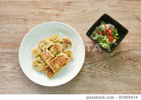 fried chicken Murtabak roti stuffed chicken on plate dipping sweet pickled cucumber sauce fried chicken Murtabak roti stuffed chicken on plate dipping sweet pickled cucumber sauce 95909424