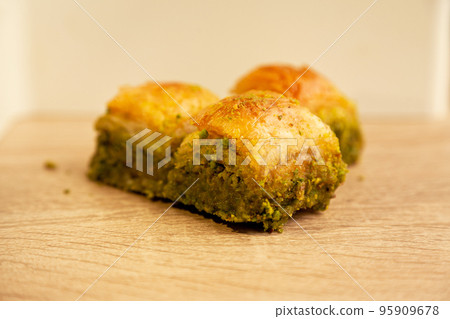Baklava with pistachio, one of the most beautiful desserts of Turkish cuisine, on oak cutting board 95909678