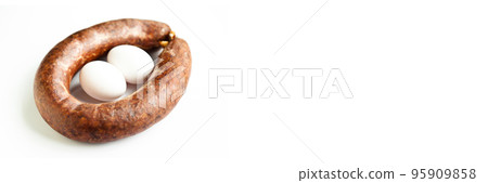 Homemade coiled sausage made of various spice mixes used in Turkish cuisine and two eggs, isolated on white background 95909858