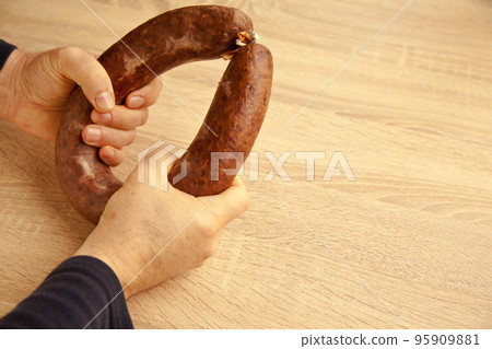 Kangal sucuk made from various spice mixtures used in Turkish cuisine, on hand and oak cutting board 95909881
