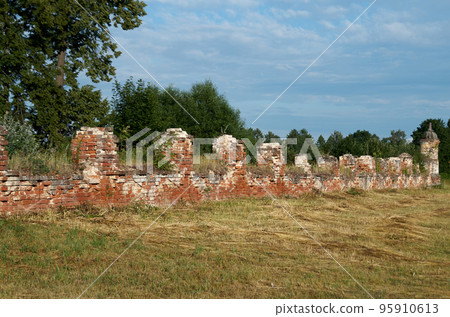 Photo of an old brick fence against the background of a summer evening sky 95910613
