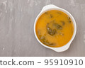 vegetable soup with crackers in white bowl on ceramic 95910910
