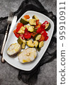 baked vegetables with boiled fish on white plate 95910911