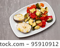 baked vegetables with boiled fish on white plate 95910912