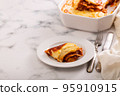 Fresh lasagna with meat and tomato sauce baked in the oven in a ceramic dish. 95910915