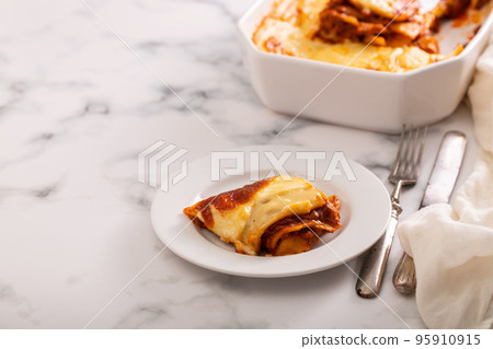 Fresh lasagna with meat and tomato sauce baked in the oven in a ceramic dish. Fresh lasagna with meat and tomato sauce baked in the oven in a ceramic dish. 95910915