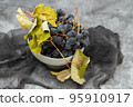 Fresh Dark blue purple grape in plate on grey background. 95910917