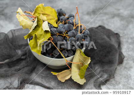 Fresh Dark blue purple grape in plate on grey background. Fresh Dark blue purple grape in plate on grey background. 95910917
