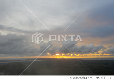 aerial view beautiful yellow sunrise above the mountain in phang Nga valley. slow floating fog blowing cover on the mountain look like as a sea of mist. scenery golden sunrise at horizon background. aerial view beautiful yellow sunrise above the mountain in phang Nga valley. slow floating fog blowing cover on the mountain look like as a sea of mist. scenery golden sunrise at horizon background. 95911095