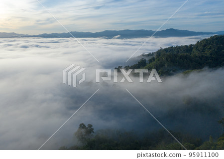 aerial view scenery sunrise above the mountain in tropical rainforest. slow floating fog blowing cover on the mountain look like as a sea of mist. beautiful sunrise in the mist background. aerial view scenery sunrise above the mountain in tropical rainforest. slow floating fog blowing cover on the mountain look like as a sea of mist. beautiful sunrise in the mist background. 95911100