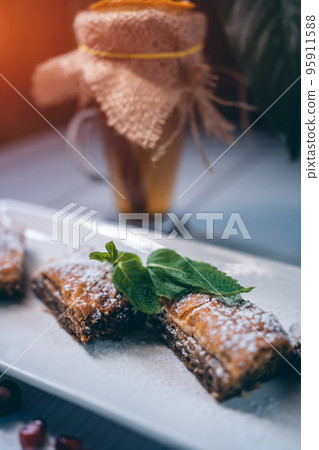delicious homemade turkish baklava with cup of hot citrus tea in restaurant 95911588