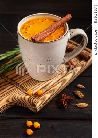 A cup of sea buckthorn hot drink on dark wooden background 95911979