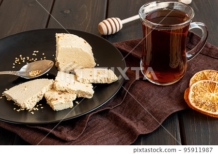 A glass of tea and tahini halva on a plate A glass of tea and tahini halva on a plate 95911987