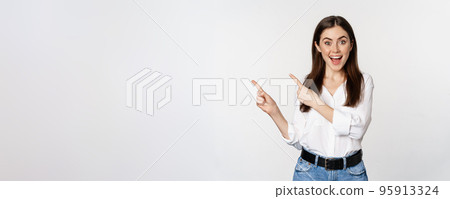 Portrait of enthusiastic smiling woman, female entrepreneur pointing fingers left and showing advertisement, showing announcement, white background 95913324