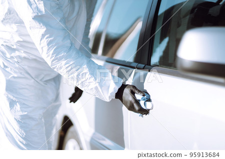 Hand of Man in protective suit washing and disinfection handles of a car.Pandemic in quarantine city Hand of Man in protective suit washing and disinfection handles of a car.Pandemic in quarantine city 95913684