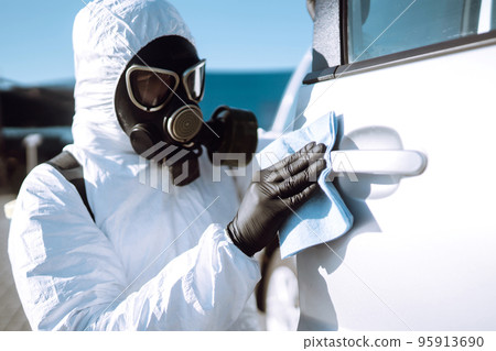 Hand of Man in protective suit washing and disinfection handles of a car.Pandemic in quarantine city Hand of Man in protective suit washing and disinfection handles of a car.Pandemic in quarantine city 95913690