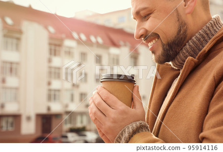 Man with cup of coffee on city street in morning 95914116