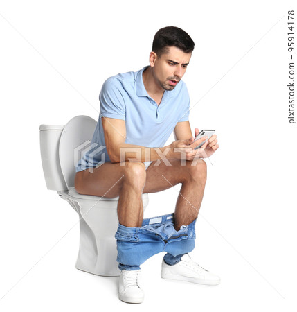 Emotional man with smartphone sitting on toilet bowl, white background 95914178