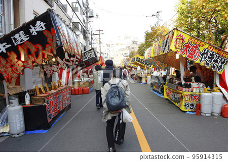 Eating while looking at the endless stalls on the festival day 95914315