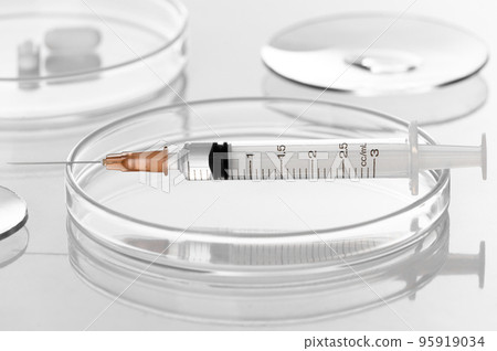Syringe with liquid transparent vaccine for injection on petri dish in medical laboratory testing white background Syringe with liquid transparent vaccine for injection on petri dish in medical laboratory testing white background 95919034