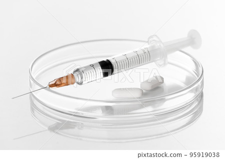Syringe with liquid transparent vaccine for injection and white pills on petri dish in laboratory white background- biochemistry- molecular biology- genetics and clinical concept Syringe with liquid transparent vaccine for injection and white pills on petri dish in laboratory white background- biochemistry- molecular biology- genetics and clinical concept 95919038