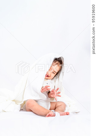 一個女嬰坐在白色背景前,穿著浴巾笑著 一個女嬰坐在白色背景前,穿著浴巾笑著 95919600