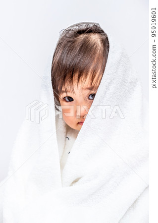 一個害羞的女嬰在白色背景前穿著浴巾的特寫 95919601