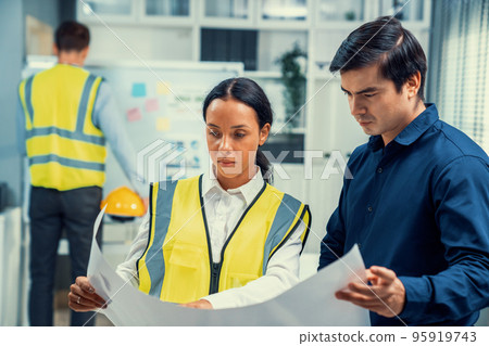 Competent investor investor discuss and brainstorm with engineers on blueprint. Competent investor investor discuss and brainstorm with engineers on blueprint. 95919743