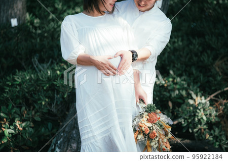 Husband putting his hand on his pregnant wife's belly Husband putting his hand on his pregnant wife's belly 95922184