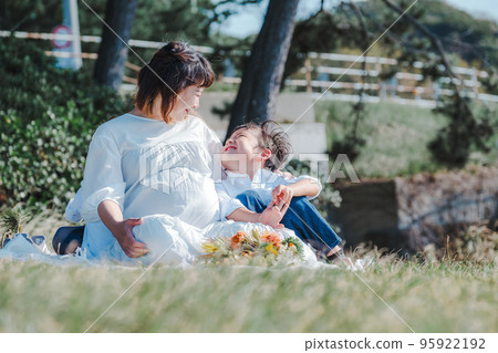 mother and sons talking on the lawn 95922192