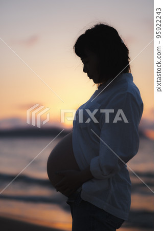 sunset and pregnant woman sunset and pregnant woman 95922243
