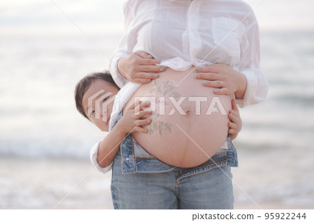 boy kissing mom's belly 95922244