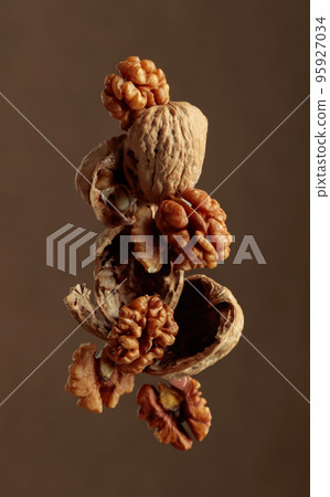 Walnuts on a brown background. 95927034