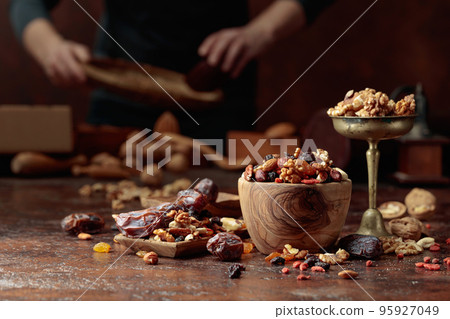 Various dried fruits and nuts on a kitchen table. 95927049