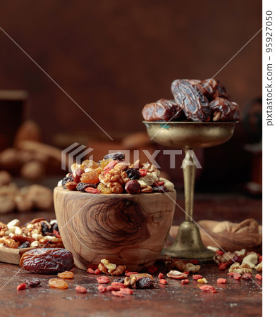 Dried fruits and nuts in a wooden bowl. 95927050