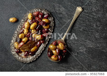 Spicy olives on a black stone table. Spicy olives on a black stone table. 95927068