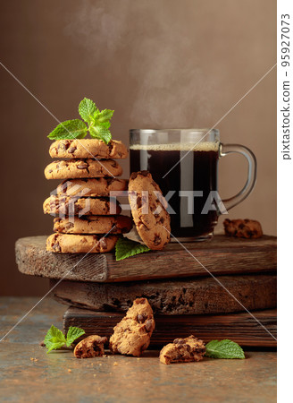 Chocolate cookies with mint and a cup of black coffee. 95927073