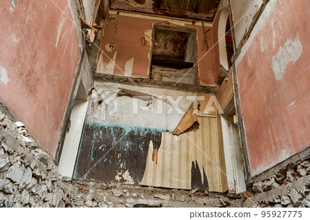 The interior of an abandoned crumbling building. A dying city. Frightening atmosphere 95927775