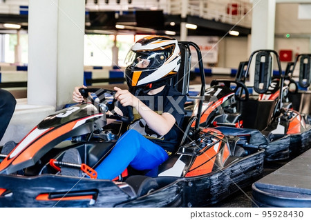 teenage boy in a racing helmet gets ready to race 95928430