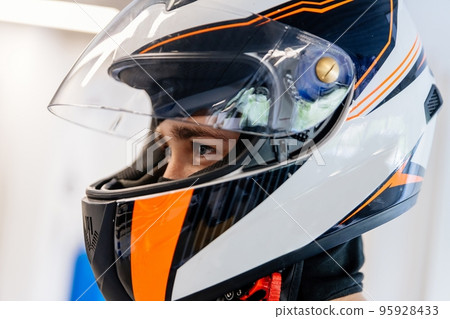 teenage boy in a racing helmet gets ready to race teenage boy in a racing helmet gets ready to race 95928433