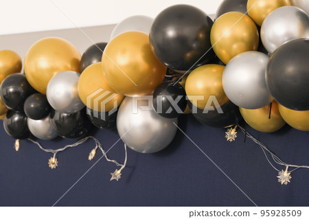 Decoration for birthday, anniversary, balloons, lights on a wall. golden and silver colored balloons. Decoration for birthday, anniversary, balloons, lights on a wall. golden and silver colored balloons. 95928509