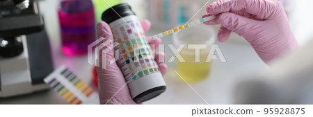 Laboratory assistant making medical test using testing strip 95928875